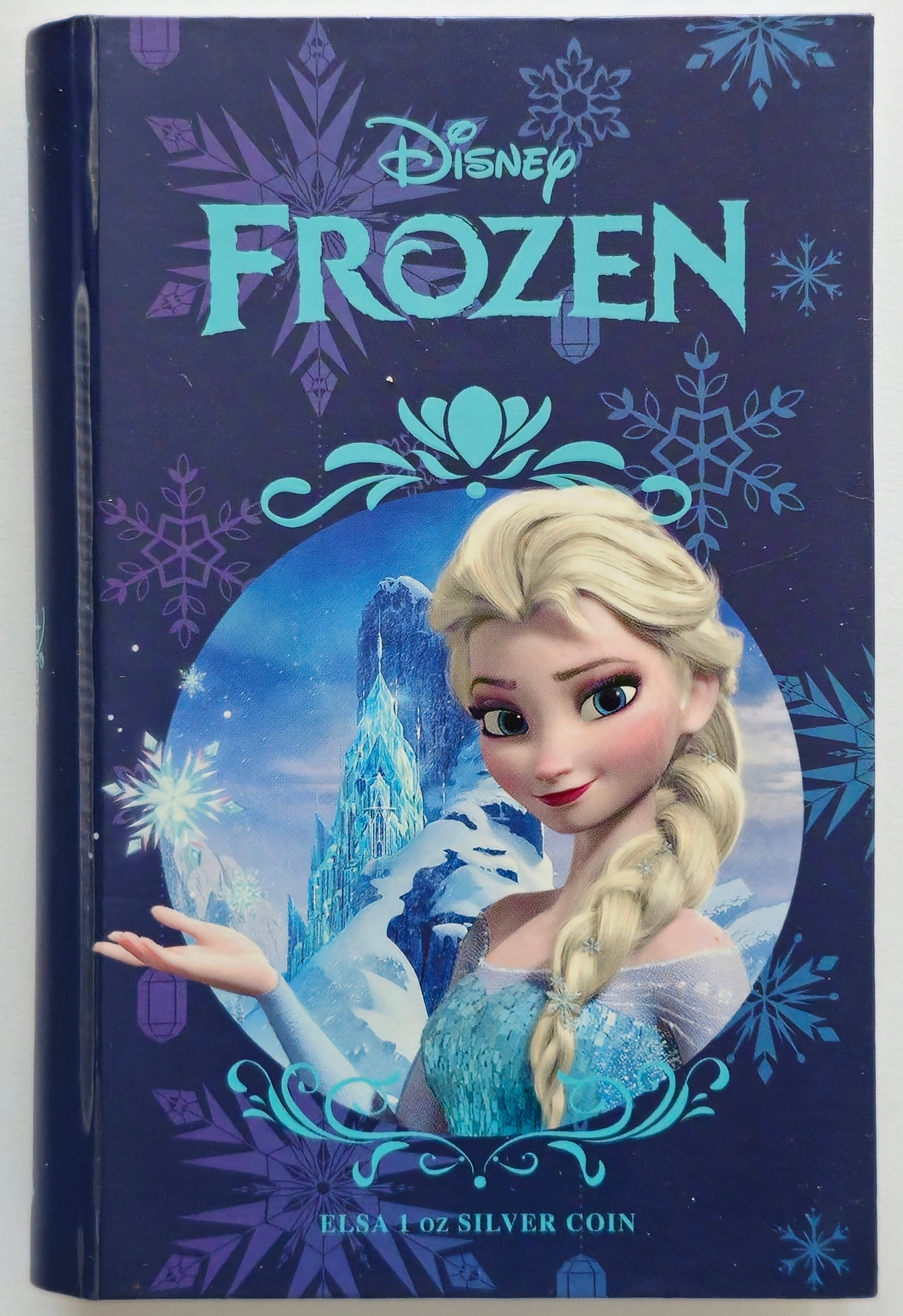 Disney Frozen Elsa 1 oz silver coin displayed inside an open presentation booklet with detailed specifications and certificate.”