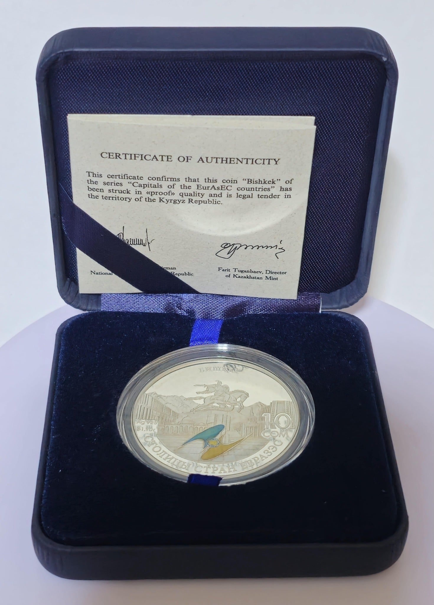 Proof-quality Kyrgyzstan 10 som silver coin displayed in a blue presentation box with an official certificate of authenticity.