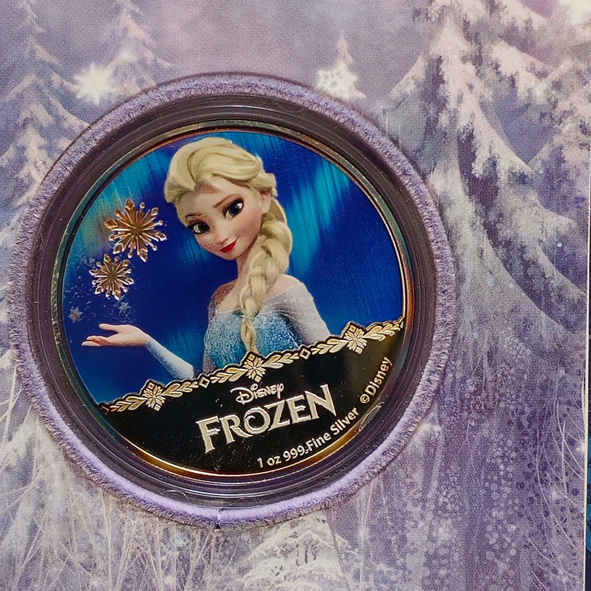 “Frozen collectible silver coin featuring Elsa, shown in an official New Zealand Mint booklet with text and artwork.”